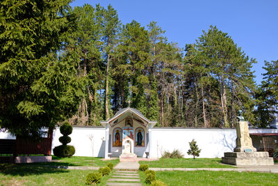 Built structure by trees against clear sky