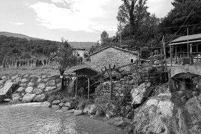 Old building by river against sky