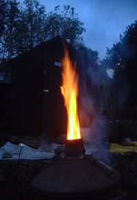 Bonfire against trees at night