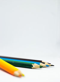 Close-up of colored pencils against white background