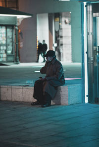 Man sitting on window of building