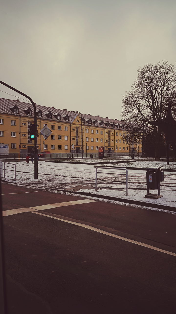 ROAD BY BUILDINGS AGAINST SKY