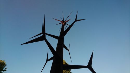 Low angle view of wind turbine against blue sky