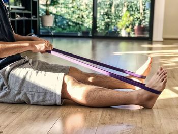 Midsection of man relaxing on table at home