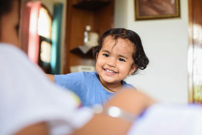 Smiling girl with mother at home