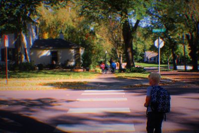 Rear view of children playing on footpath in park