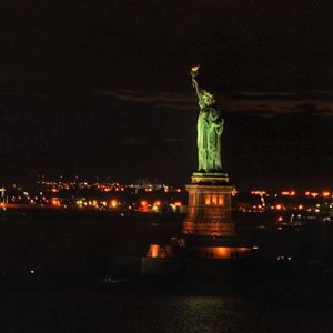Statue of illuminated city at night