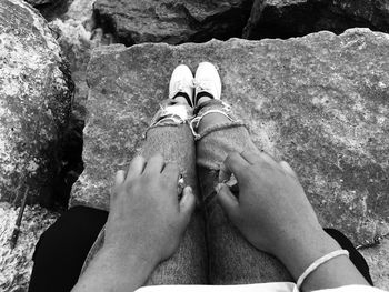 Low angle view of person sitting on rock