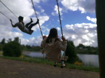 Rear view of girl on swing at playground