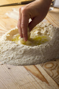 Cropped image of hand preparing ravioli dough on table