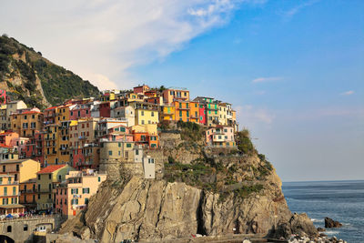 Panoramic view of buildings by sea against sky