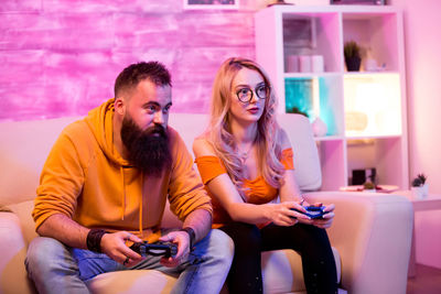 Friends sitting on sofa at home