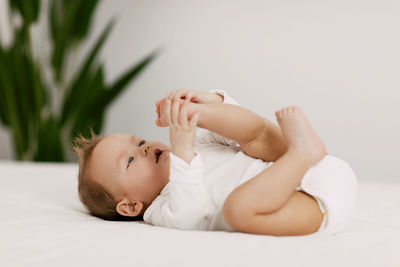 Portrait of cute baby lying on bed