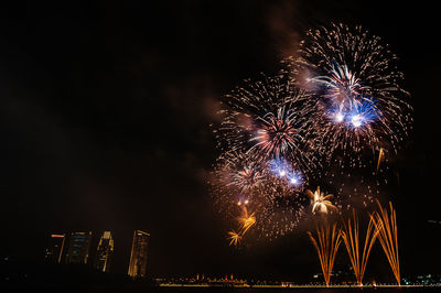 Low angle view of firework display at night