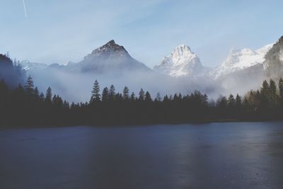 Scenic view of lake and mountains against sky during winter