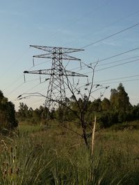 Low angle view of electricity pylon against clear sky