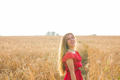 Smiling young woman standing on field