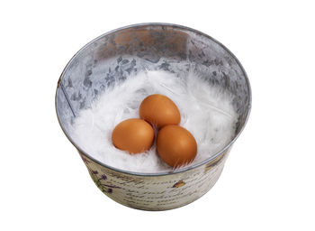 Close-up of eggs in bowl against white background