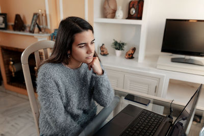 Young woman using mobile phone at home