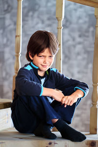 Portrait of boy sitting on railing