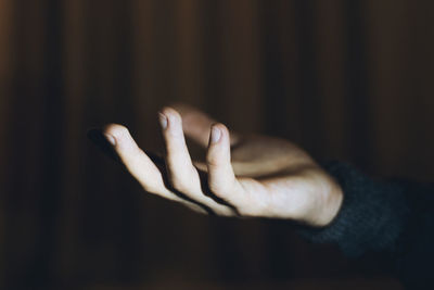 Close-up of human hand over black background