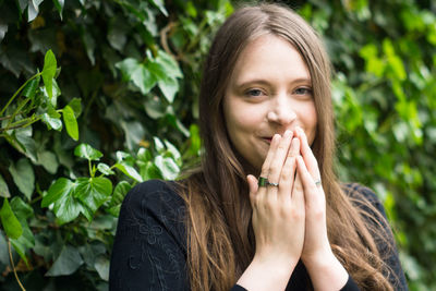 Portrait of young woman against plants