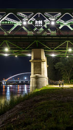 View of bridge over river at night
