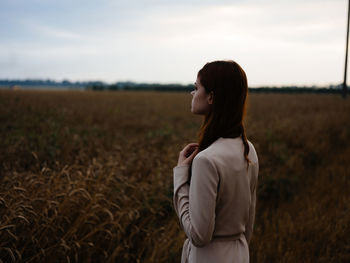 Woman standing on field against sky