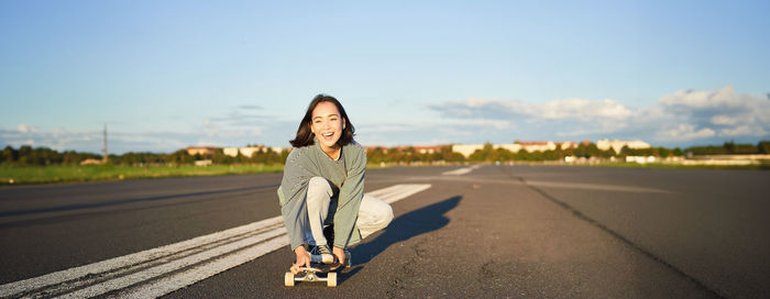 Rear view of woman standing on road against sky