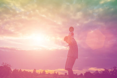 Side view of silhouette man standing against sky during sunset