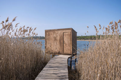 Footpath by sea against clear sky