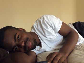 Portrait of man lying on bed at home