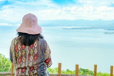 Rear view of woman looking at sea against sky