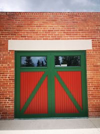 Red closed door of brick wall