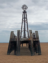 Built structure on beach against sky