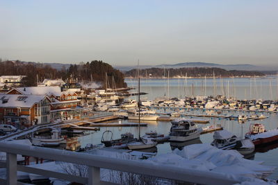 Boats moored at harbor against sky