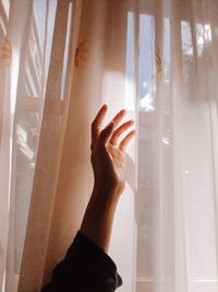 Close-up of woman hand on window