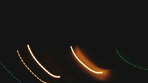 Close-up of illuminated lights over black background