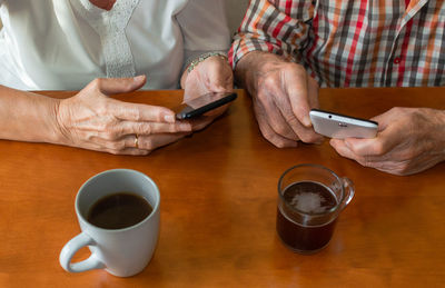 Midsection of man using laptop on table