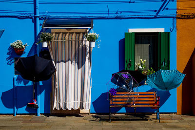 Multi colored chairs and tables against blue building