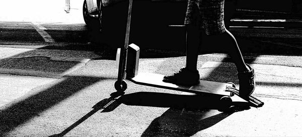 Close-up low section of shadow on tiled floor