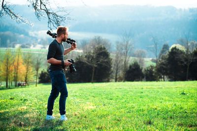 Full length of man standing on field against trees in forest