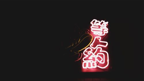 Low angle view of illuminated lantern against black background