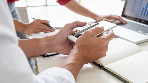 Midsection of man using laptop on table