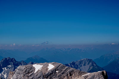 Scenic view of snowcapped mountains against blue sky