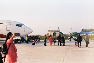 Group of people walking towards plane