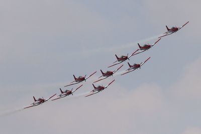 Low angle view of fighter planes flying against sky