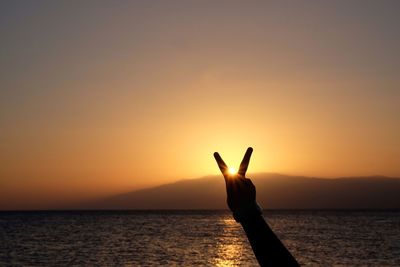 Silhouette of man in sea at sunset