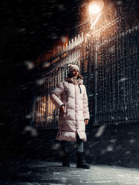 Woman standing on wet street in snow