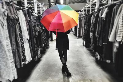 Rear view of woman with umbrella standing in market